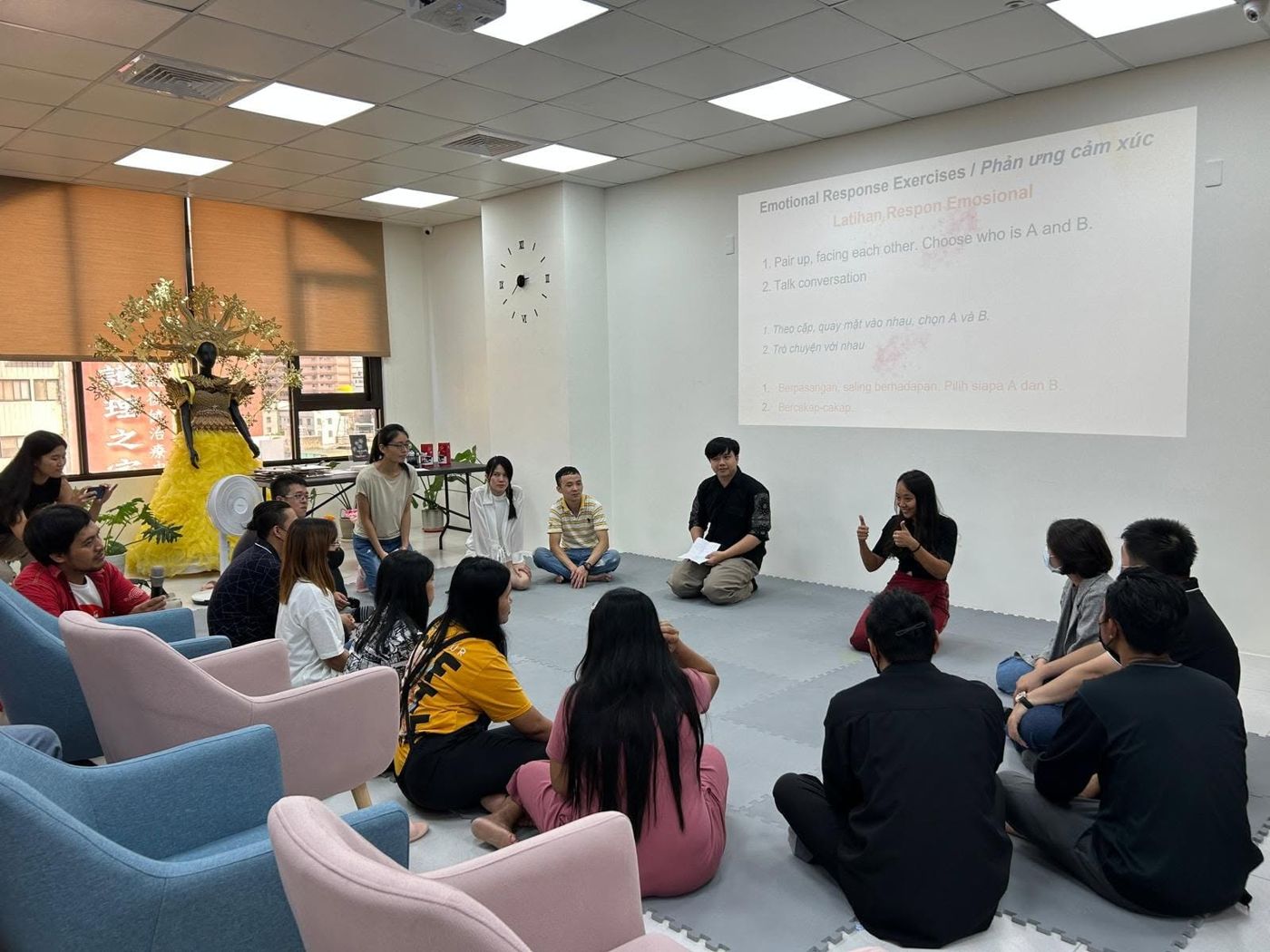 Wasu leading a storytelling workshop with migrant workers in Taiwan, participants seated in a circle